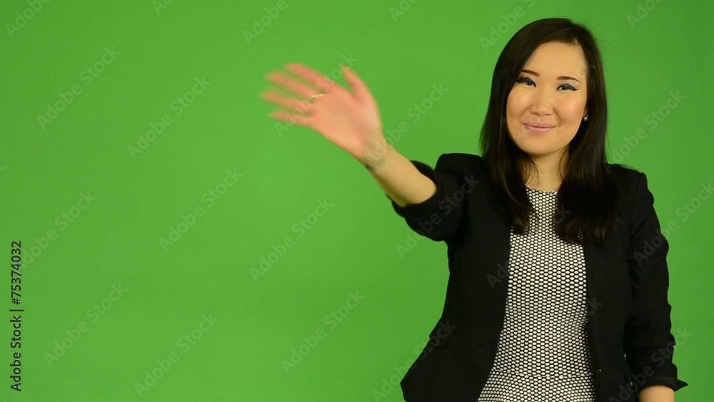 asian woman waves with hand - green screen