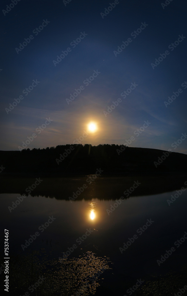 Midnight summer landscape with fool moon over a lake