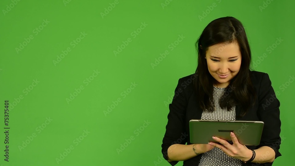asian woman works on tablet and smiles - green screen asian woman works on tablet and smiles - green screen
