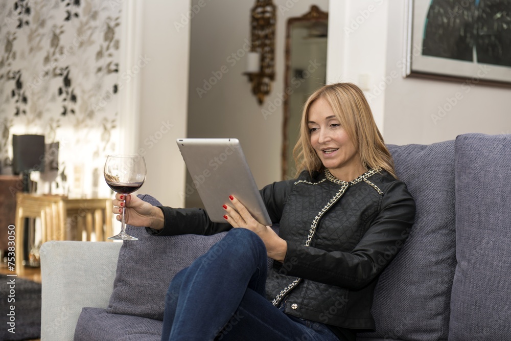 Young Woman Reading a Digital Tablet on Sofa Young Woman Reading a Digital Tablet on Sofa