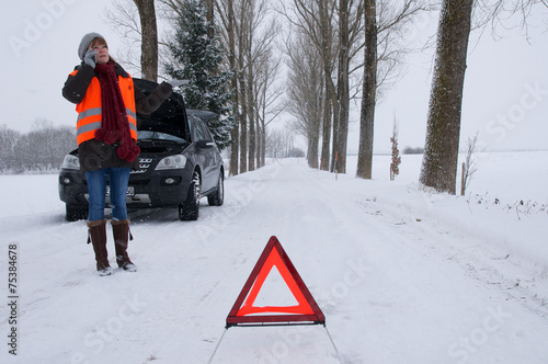 Junge Frau hat Autopanne im Winter