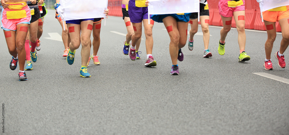 marathon athletes legs running on city road marathon athletes legs running on city road
