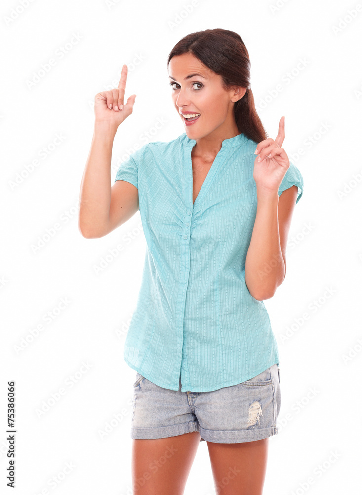 Beautiful latin girl in short jeans pointing up Beautiful latin girl in short jeans pointing up