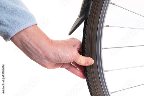 Billede på lærred Hand checks the amount of air in a bicycle whee