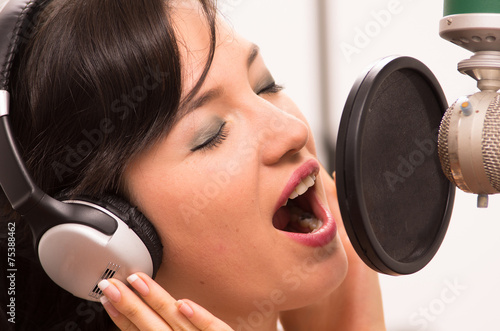 beautiful young girl singing in music studio