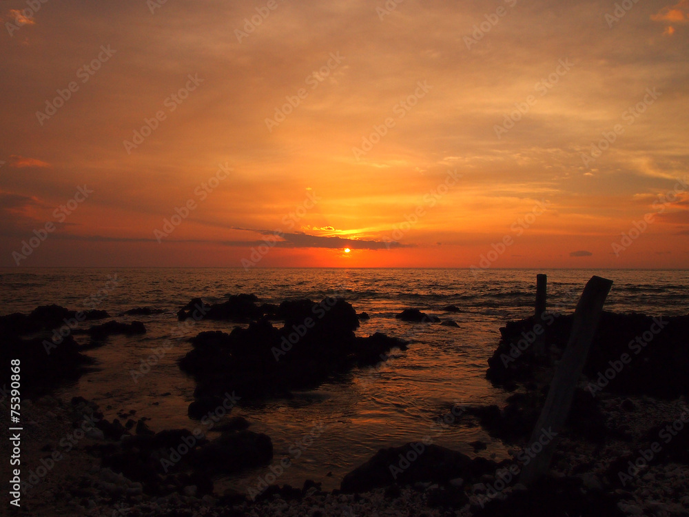 Sunset over ocean with lava rocks of Holoholokai Beach in the fo Sunset over ocean with lava rocks of Holoholokai Beach in the fo