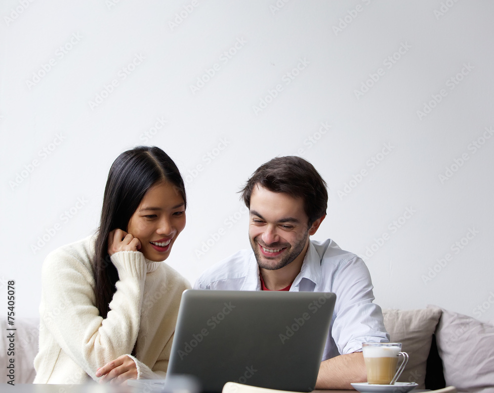 Happy young couple working on laptop at home Happy young couple working on laptop at home