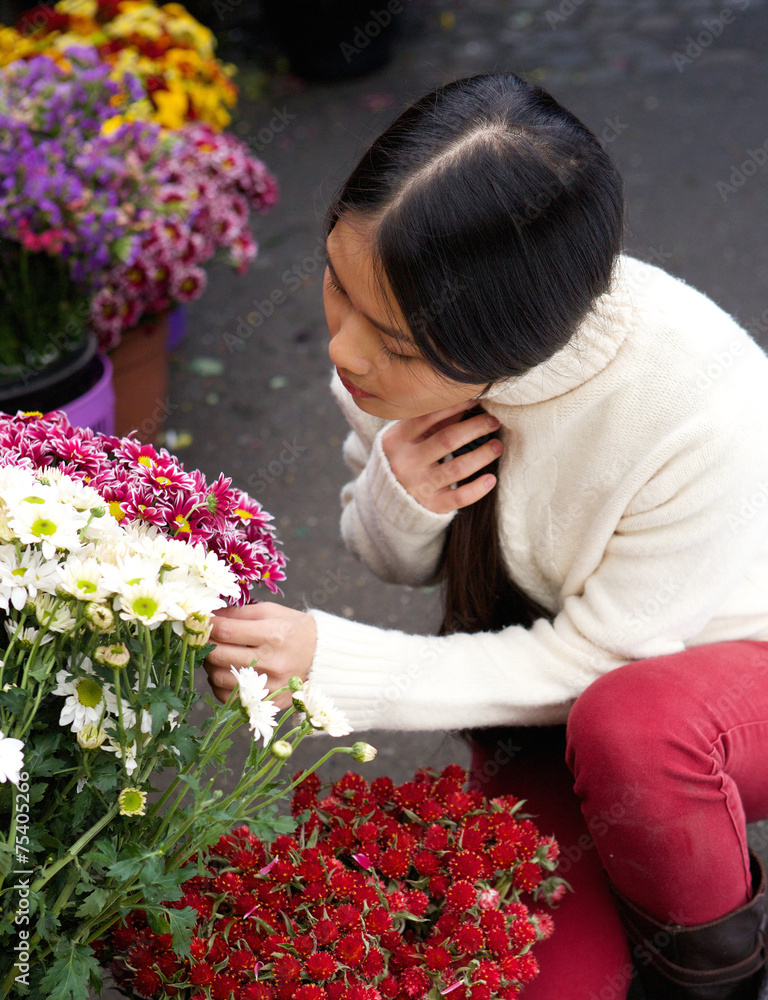 Young asian woman looking at flowers at store Young asian woman looking at flowers at store