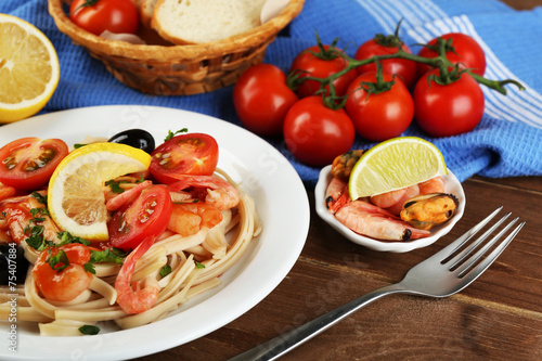 Tasty pasta with shrimps, mussels, black olives and tomato