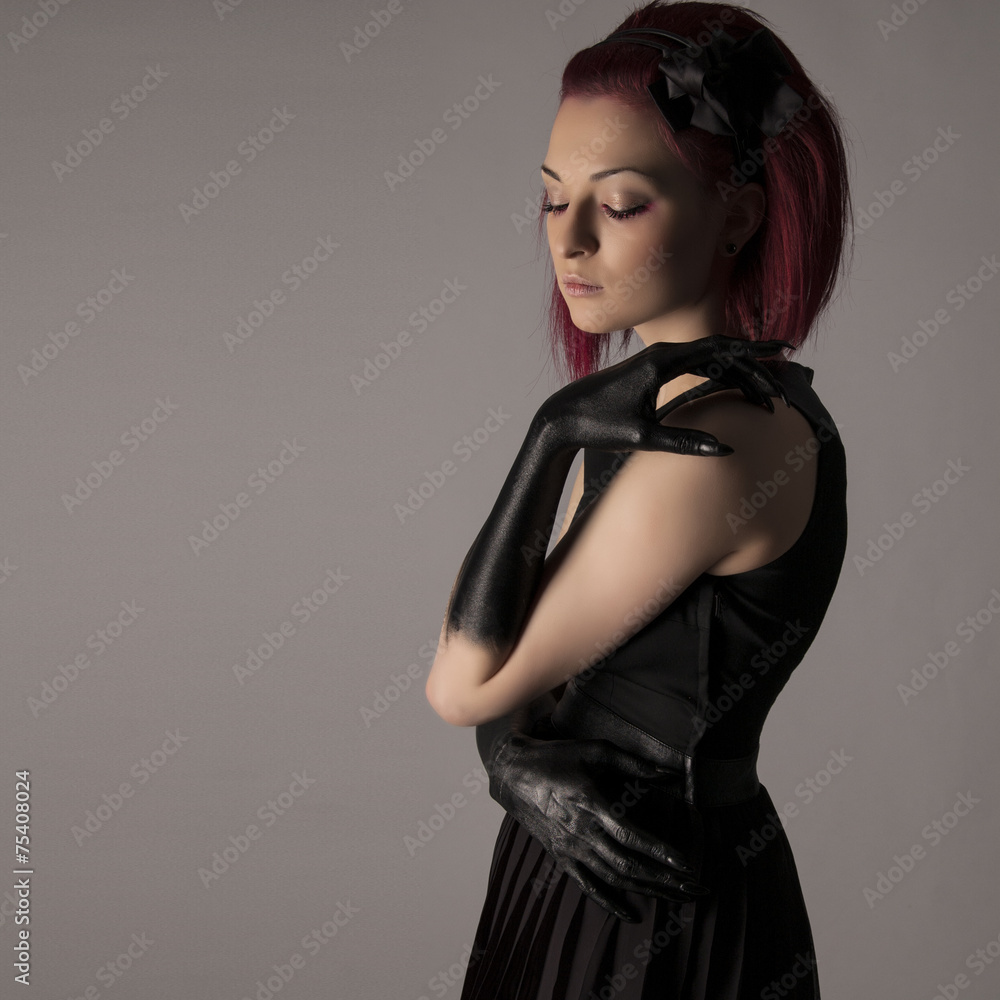 Fototapeta premium Beautiful woman with red hair and black paint on hands