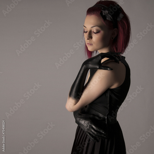 Beautiful woman with red hair and black paint on hands