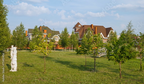 Tableau sur toile City park with lawn, with  bridge and garden sculpture