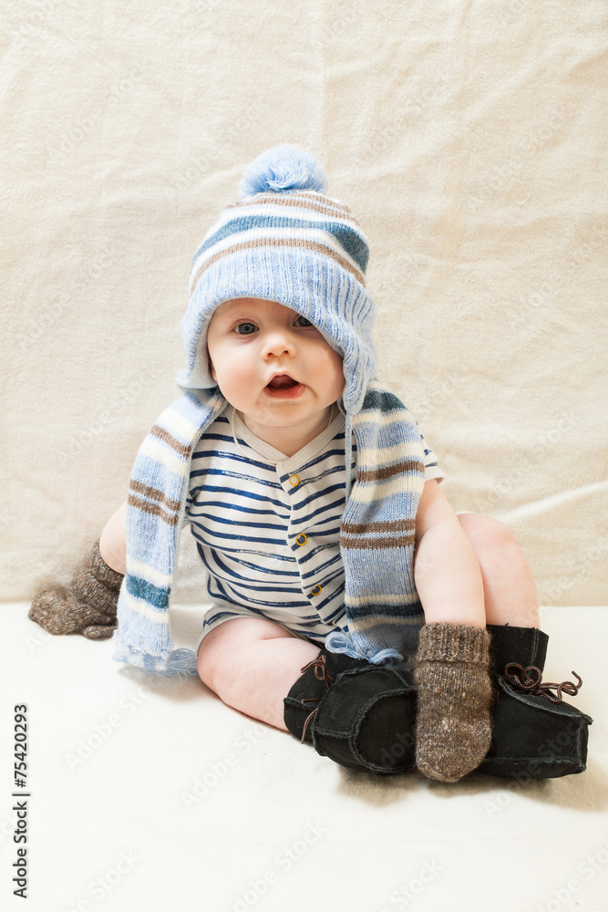 Cute baby boy wearing of warm knitted hat , gloves , Ugg boots Stock Photo  | Adobe Stock