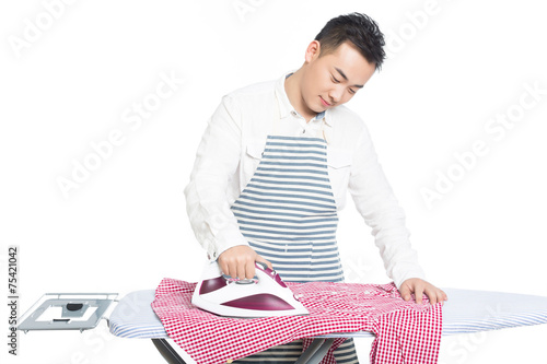chinese young man ironing his clothes
