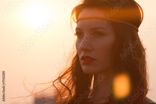Portrait hippie woman with headband looking far away at sunset