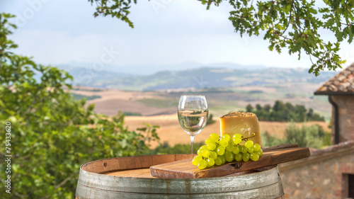 Cheese and grapes on a barrel in the Tuscan landscape Italy