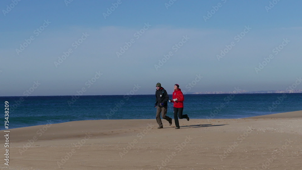 Middle-aged Couple Jogging on Ocean Sandy Beach Middle-aged Couple Jogging on Ocean Sandy Beach