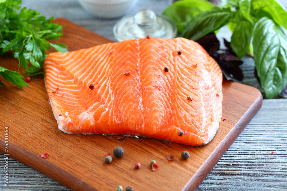 Red fish fillet with greens on a cutting board Red fish fillet with greens on a cutting board