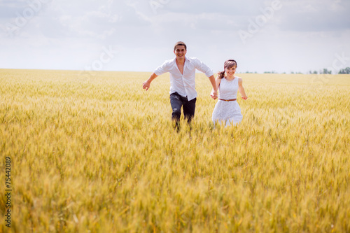 series. a love story. couple runs in the wheat field and smiling