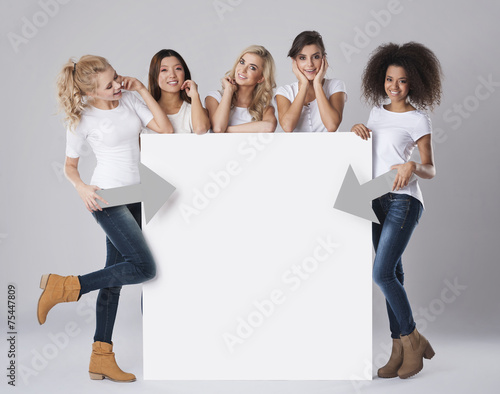 Multi ethnic women with empty billboard