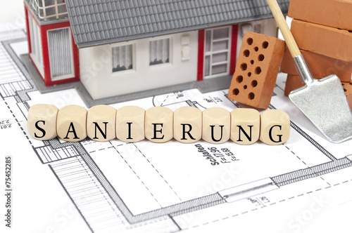Bauplan mit Ziegelsteinen und Sanierung