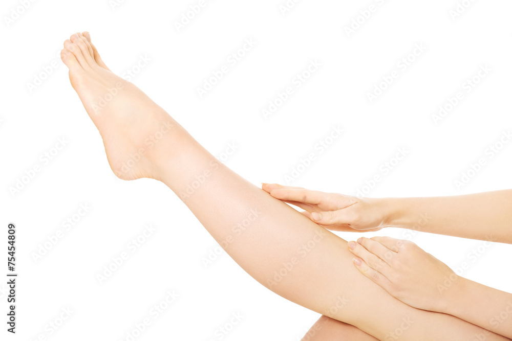 Side view of a woman massaging her leg