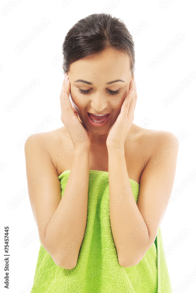 Surprised woman wrapped in towel touching her face Surprised woman wrapped in towel touching her face