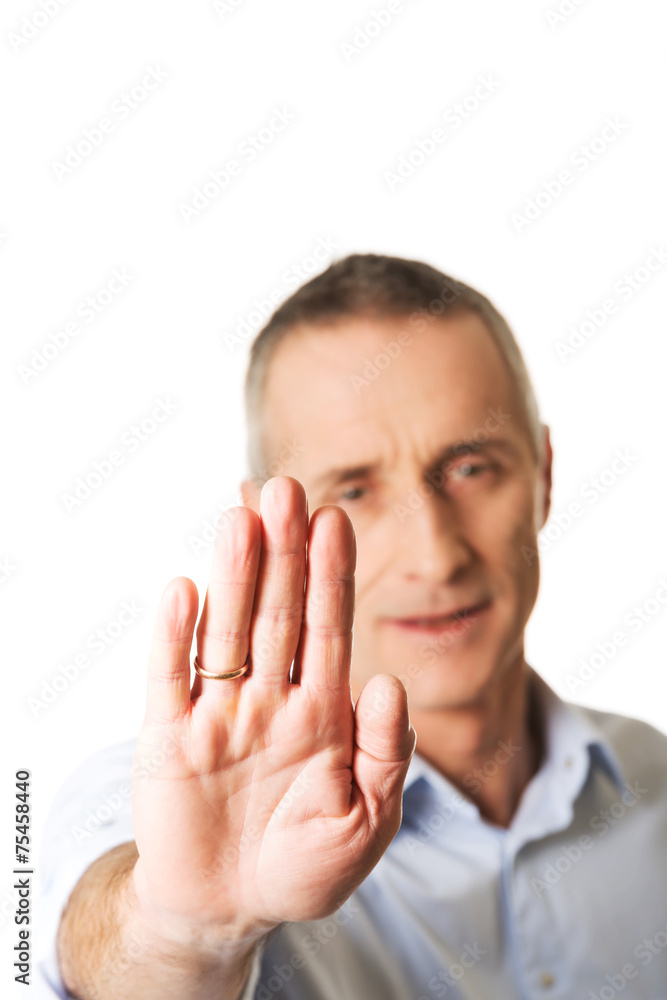 Portrait of mature man making stop sign with hand Portrait of mature man making stop sign with hand