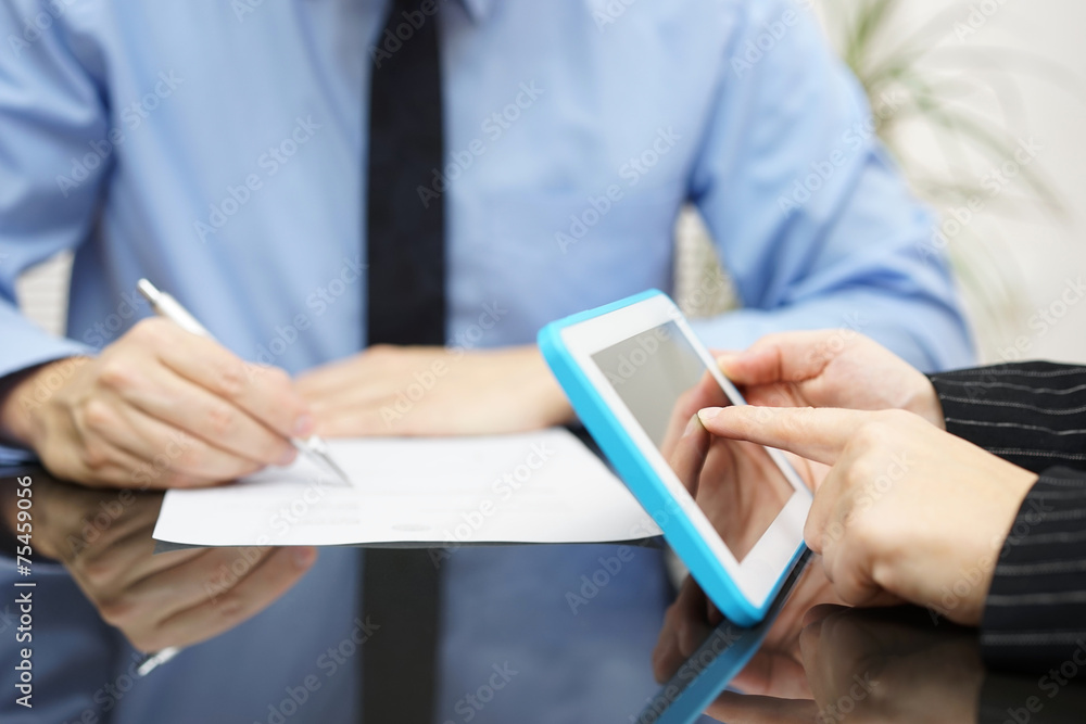 businesswoman is working with tablet pc and businessman is writi businesswoman is working with tablet pc and businessman is writi