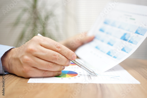 Financial adviser is reviewing report with charts and graphs