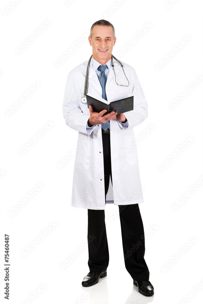 Full length mature male doctor holding notebook Full length mature male doctor holding notebook