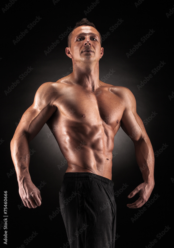 Fototapeta premium Muscular man in studio on dark background
