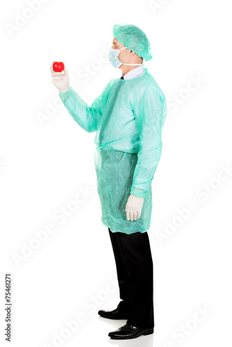 Full length of male doctor holding heart model