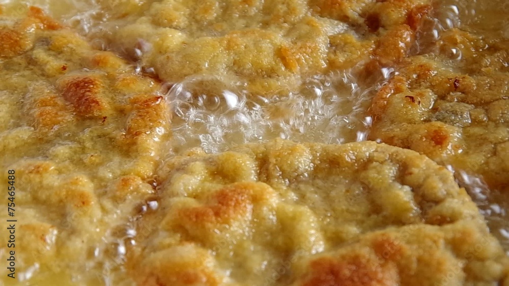 Frying pork meat coated with breadcrumbs in a pan Frying pork meat coated with breadcrumbs in a pan