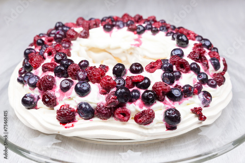 Pavlova Raspberries and blueberries foam pie on glass scale