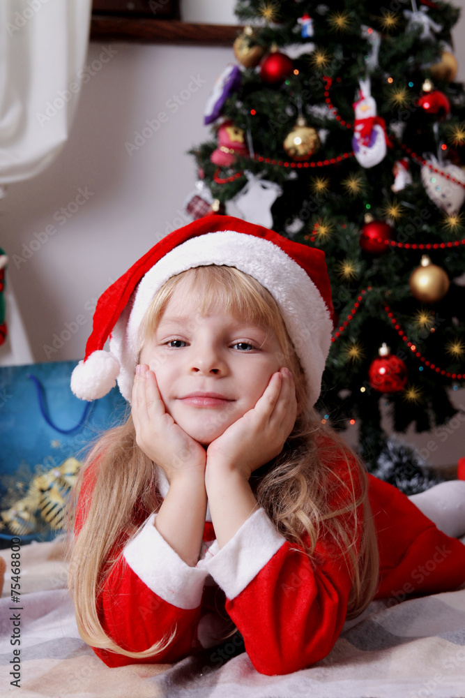 Santa helper lying under Christmas tree Santa helper lying under Christmas tree