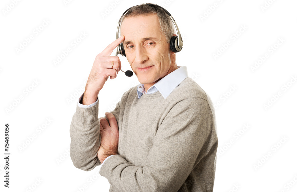 Call center man wearing a headset touching head Call center man wearing a headset touching head