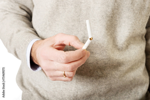 Close up on male hand with broken cigarette