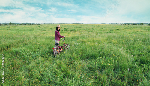 Girl walking with bicycle in summer