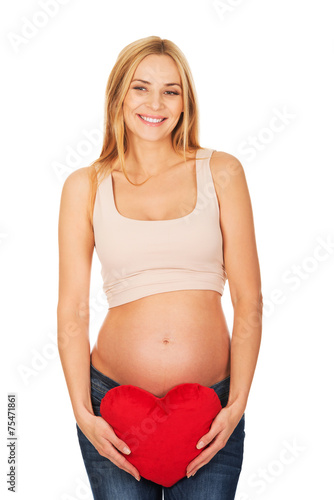 Pregnant woman with a heart pillow