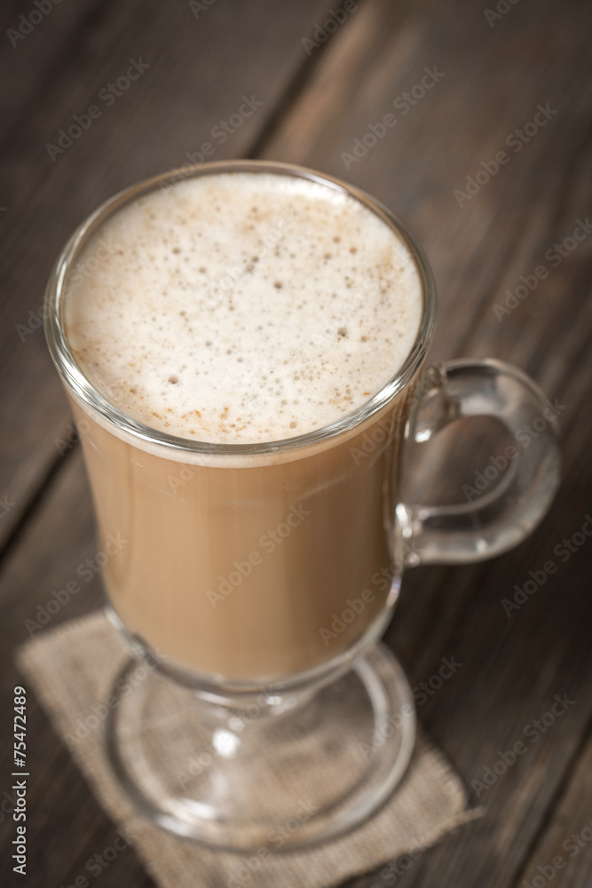 Coffee cup with warm latte standing on wooden table Coffee cup with warm latte standing on wooden table