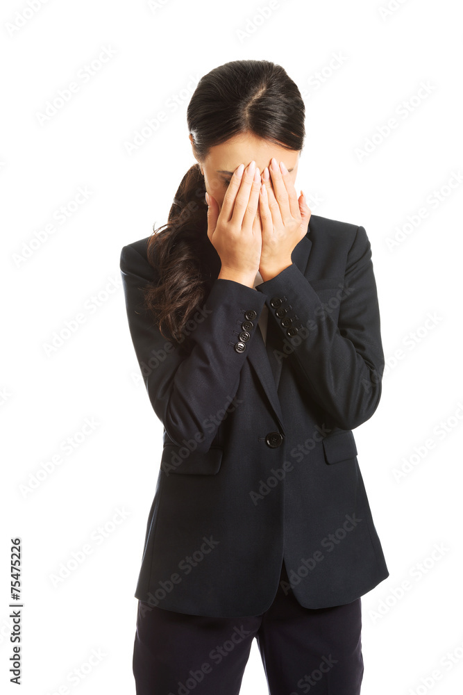 Businesswoman covering her face because of shame Businesswoman covering her face because of shame