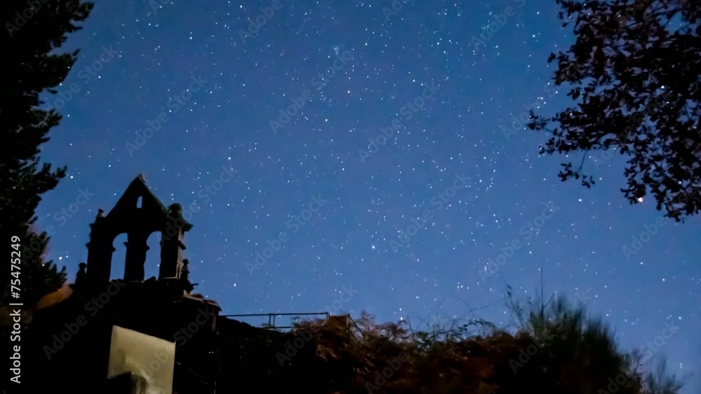 Time lapse, campanario bajo las estrellas