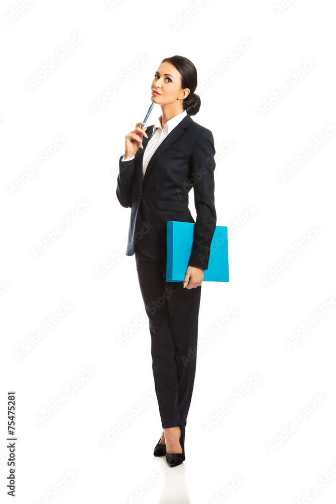 Full length thoughtful businesswoman holding a pen Full length thoughtful businesswoman holding a pen