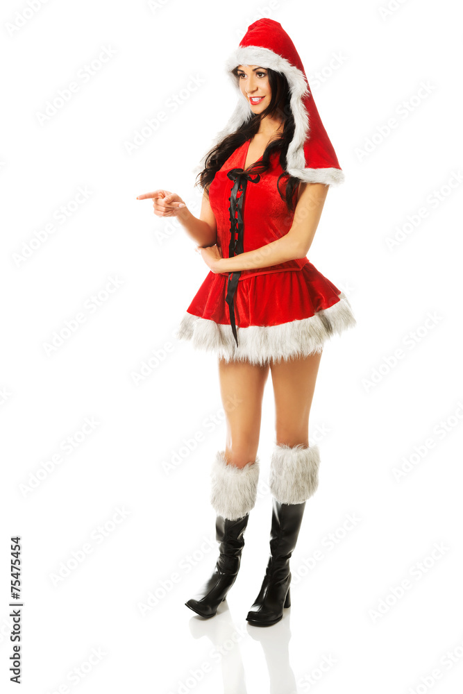 Woman wearing santa clothes pointing left Woman wearing santa clothes pointing left