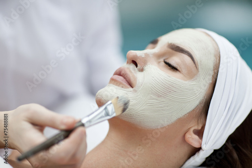 A young woman with a face pack. 