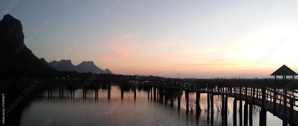 Obraz premium Silhouette pavilion and wooden bridge at the mountain