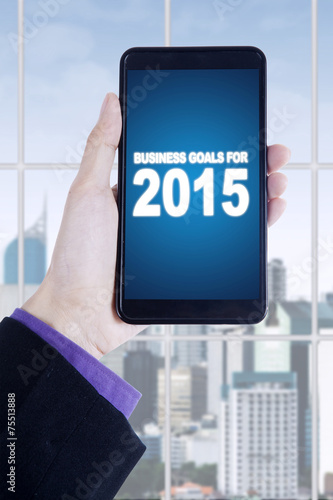 Hands with business goals on smartphone