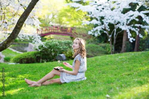 Wallpaper Mural Girl eating sushi in cherry blossom garden Torontodigital.ca
