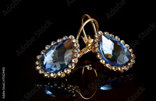 Earrings from gold against a dark background.